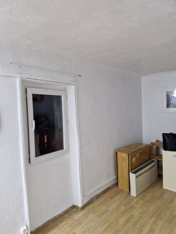 Après : mur blanc repeint autour de la fenêtre, plafond refait
